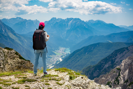Hiker woman standing up achieving the top. National Nature Park Tre Cime In the Dolomites Alps. Beautiful nature of Italy.の写真素材
