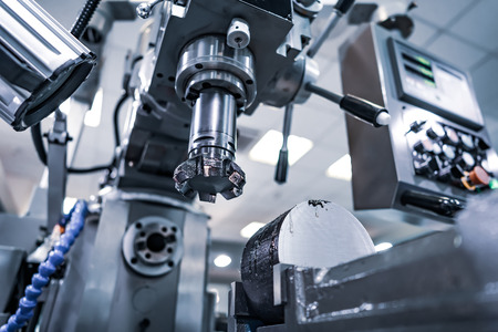 Metalworking CNC milling machine. Cutting metal modern processing technology. Small depth of field. Warning - authentic shooting in challenging conditions. A little bit grain and maybe blurred.の写真素材