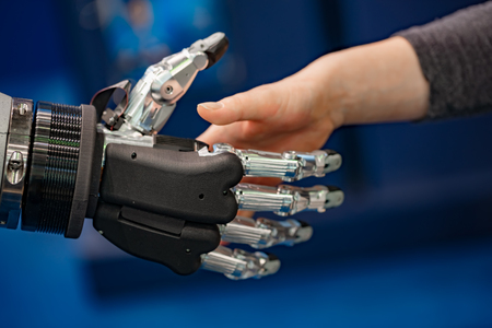 Hand of a businesswoman shaking hands with a   robot.