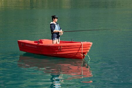 Woman fishing on a boat. Beautiful Nature Norway natural landscape.の写真素材