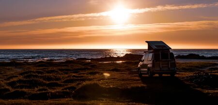 Camping car minivan on the beach at sunset.の写真素材