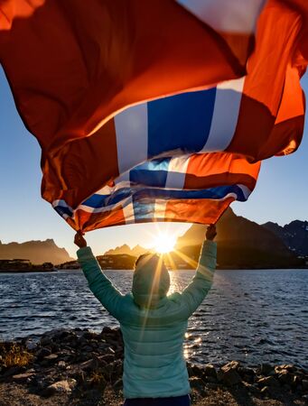 Woman waving the flag of Norway at sunsetの写真素材