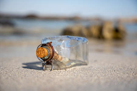 Message in the bottle against the Sun setting downの写真素材