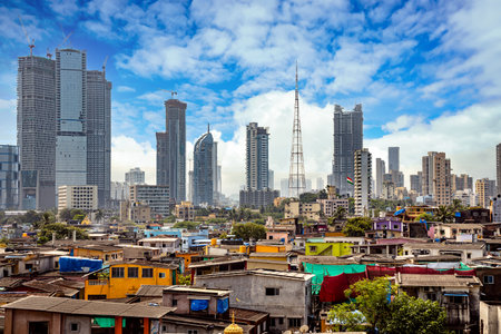 Views of slums on the shores of mumbai, India against the backdrop of skyscrapers under constructionのeditorial素材