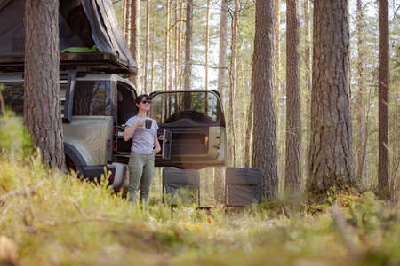 Trip in the nature by car family vacation on the weekend. Woman traveler enjoy coffee time.