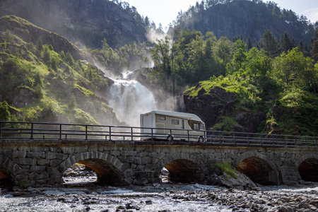 Holiday trip in motorhome, Caravan car Vacation. RV traveling on the road Latefossen Waterfall Odda Norway. Latefoss is a powerful, twin waterfall.の写真素材