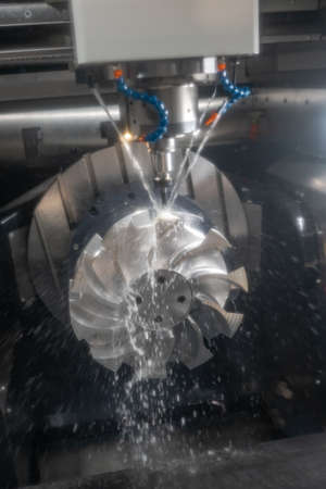 Metalworking CNC milling machine. Cutting metal modern processing technology. Small depth of field. Warning - authentic shooting in challenging conditions. A little bit grain and maybe blurred.の写真素材