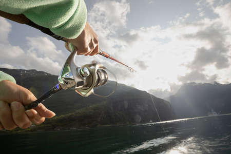 Woman fishing on Fishing rod spinning in Norway. Fishing in Norway is a way to embrace the local lifestyle. Countless lakes and rivers and an extensive coastline means outstanding opportunities...の写真素材