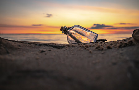 Message in the bottle against the Sun setting downの写真素材