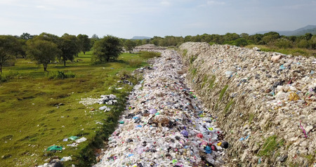 Bird's eye view of garbage mountain from drone in the industrial zone. See the employee take garbage to sell to earn extra income. Here is a flock of white birds, living in the garbage dump.の写真素材