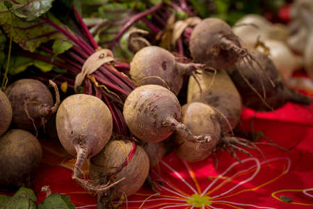 Local produce at a Farmers Market. Bunches of beets on a table ready for sale.