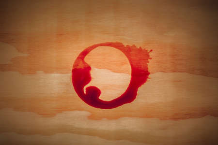A red wine stain on a wooden background, a design template with a place for text or logo for a...