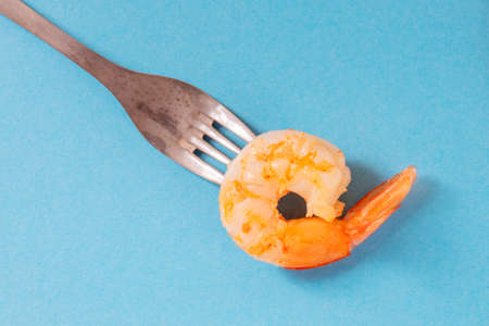 Shrimp on a fork, shot from the top on a blue backgroundの写真素材
