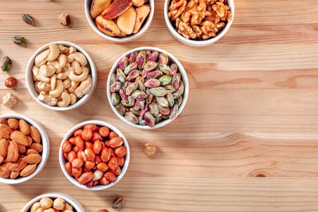 Nuts background with a place for text, overhead shot on a wooden backgroundの写真素材