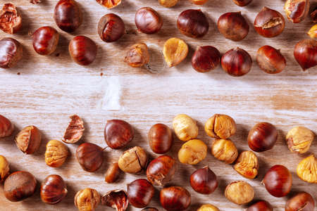 Chestnuts banner with copy space, a design template for an autumn menu or invitation, overhead flat lay shot on a rustic wooden backgroundの写真素材