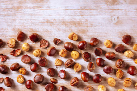 Chestnuts, overhead flat lay shot on a rustic wooden background with a place for textの写真素材