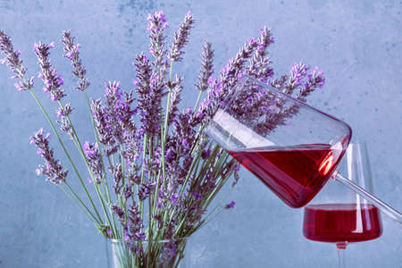 Rose wine in trendy glasses and a bouquet of lavender flowers, a vin de Provence wine tastingの写真素材