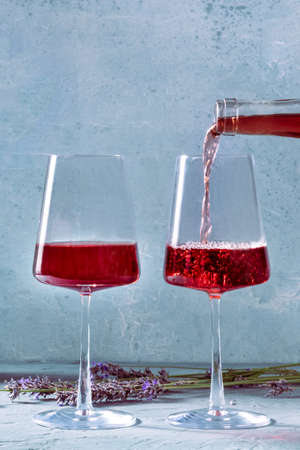 Two glasses of rose wine with a place for text and a bunch of lavender flowers, the wines of...