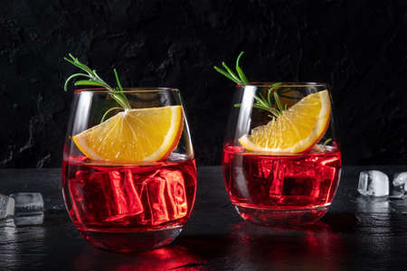 Aperol cocktail with orange and rosemary garnish, on a black slate background. Alcoholic drinkの写真素材
