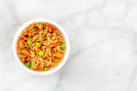 Ramen cup, instant soba noodles in a plastic cup with vegetables, shot from above with a place for textの写真素材