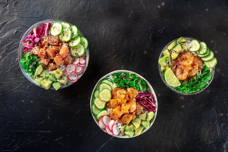 Poke bowl variety. Healthy Hawaiian dish with salmon, tuna, and shrimps, overhead flat lay shot on a black backgroundの写真素材
