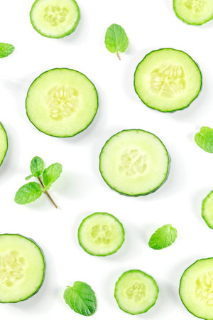 Fresh cucumber slices and mint leaves on white, top shot. Healthy organic vegan foodの写真素材