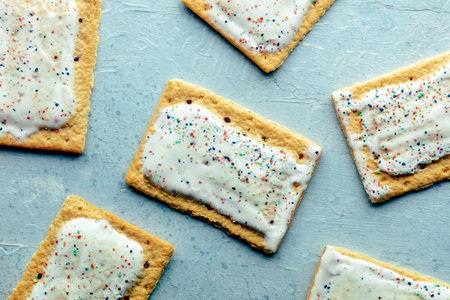 Pop tarts layout. Poptart toaster pastry with icing on a blue slate background, overhead flat lay...