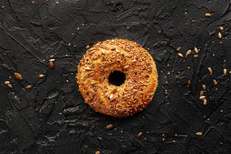 A single bagel, overhead flat lay shot on a black backgroundの写真素材