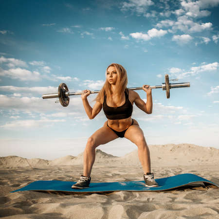 Strength training on the beach. Pretty athlete doing exercise in a closed shoe.のeditorial素材