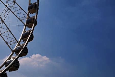 Part of Ferris wheel against blue sky