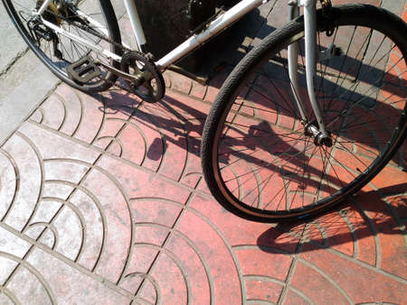 Bicycles leaning against electric pole in hard day lightの写真素材