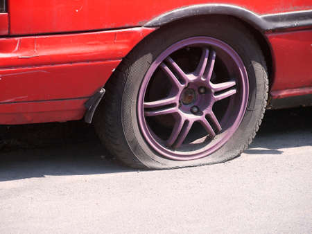 Dirty old red car tire break deflatedの写真素材