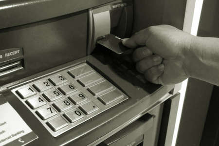 Man hand insert card to automated teller machine ATM black and white