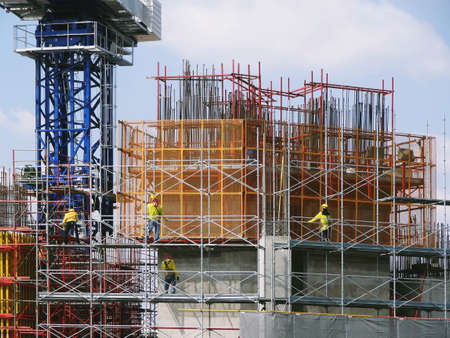 Big construction site with worker wear safety helmet and safety sling working on high scaffolding