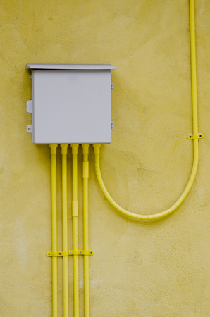 electrical box out door,on yellow wallの写真素材