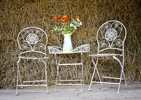 White iron chairs and table in the barnの写真素材