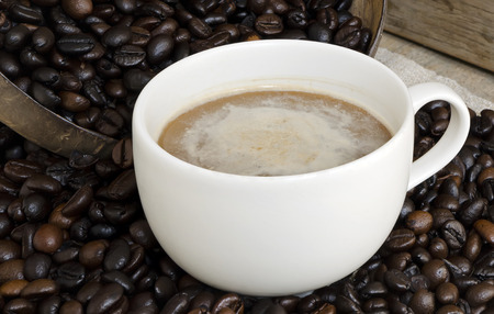White cup of coffee on coffee beans .の写真素材