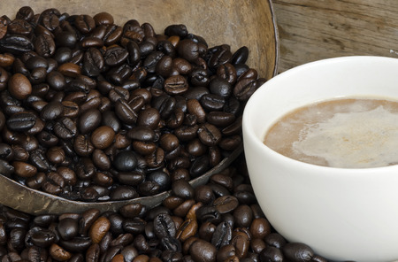 Fresh coffee bean in coconut shell and a cup of coffee.の写真素材