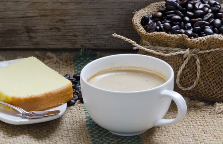 Cup of coffee and piece of cake on a wooden backgroundの写真素材
