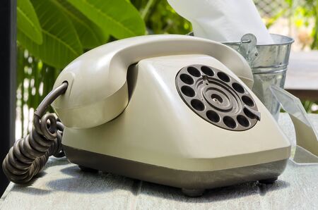 Vintage dial telephone on the table under the sun light.の写真素材