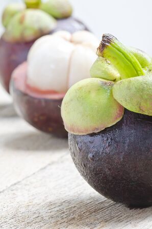 Fresh mangosteen fruit on wooden background  in close up view,shallow DOF.の写真素材