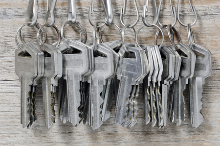 Bunch of old iron keys hang on the wooden wall.の写真素材