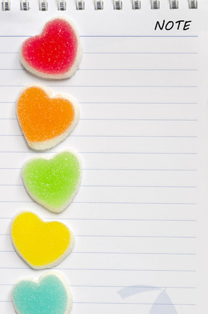 Colorful of jelly candy with heart sign on blank white note  paper background.の写真素材