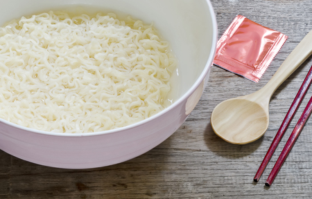Pink bowl of chinese noodles on wooden background.Close up view.の写真素材