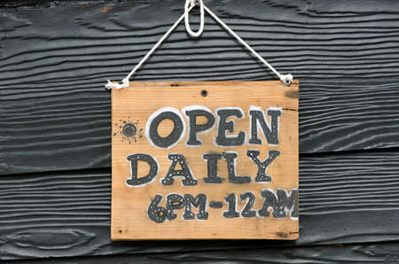 Wooden open sign hang on black wall.の写真素材