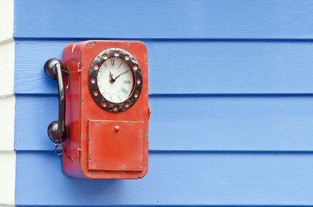 Vintage clock in telephone style hang on the blue wallの写真素材