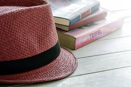 THe red weave hat and the old books on wooden table.の写真素材