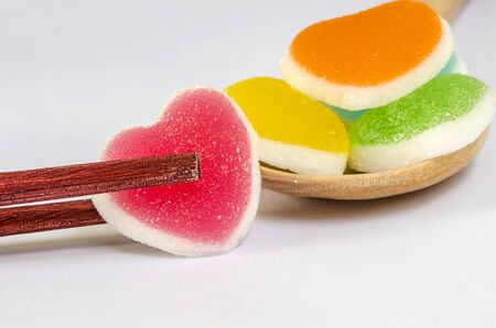 Heart shape of jelly candy in chopsticks  on white background.の写真素材