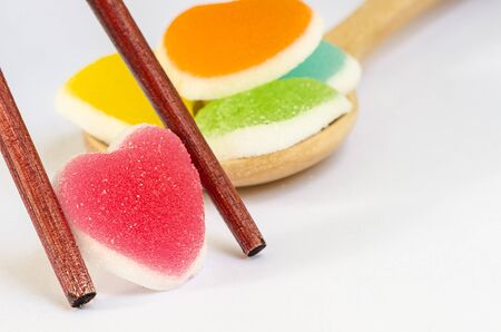 Heart shape of jelly candy in chopsticks  on white background.の写真素材