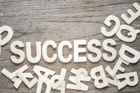 Stack of wood letters as success word on wooden background.の写真素材